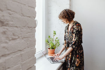 Woman working by a sunny window, where UVA rays pass through glass